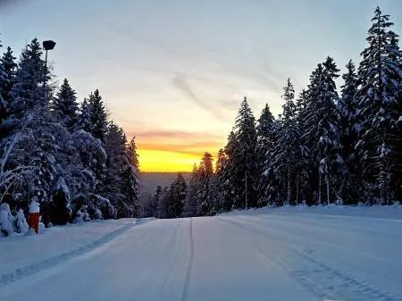 Skilift im verschneiten Schwarzwald bei Sonnenuntergang, ideal für Wintersport.