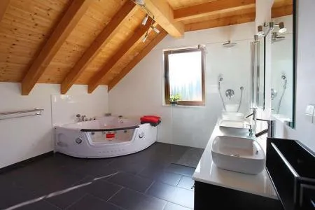 Modernes Badezimmer mit Wellnessbadewanne und Doppelwaschbecken im Schwarzwald.