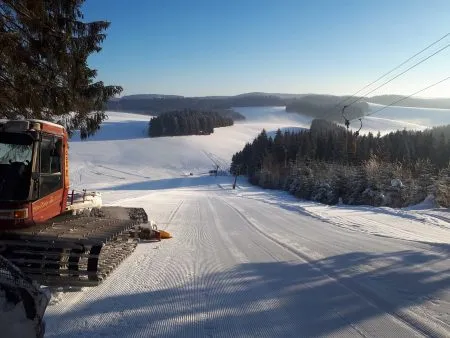 Skilift Thurner im Winter mit verschneiten Pisten und Blick auf die verschneite Landschaft im Schwar.