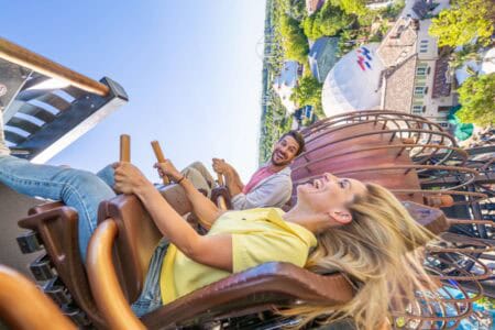 Zwei Personen auf einer Achterbahn im Europa-Park, lachend und Spaß habend.